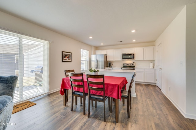 dining room featuring dark wood-type flooring, recessed lighting, and baseboards