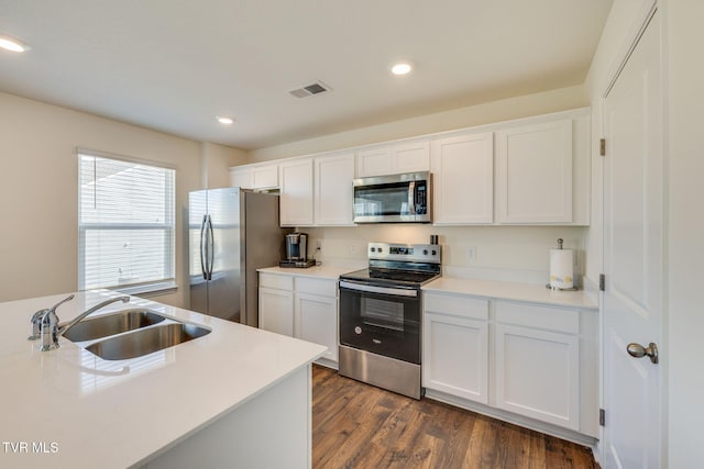 kitchen with stainless steel appliances, light countertops, and white cabinetry