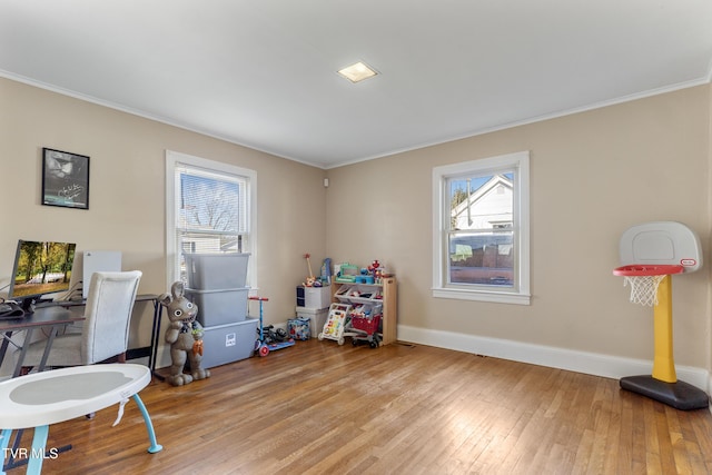 rec room featuring light wood finished floors, baseboards, and crown molding