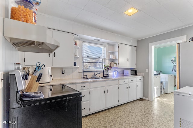 kitchen featuring washing machine and dryer, white cabinetry, open shelves, and light countertops