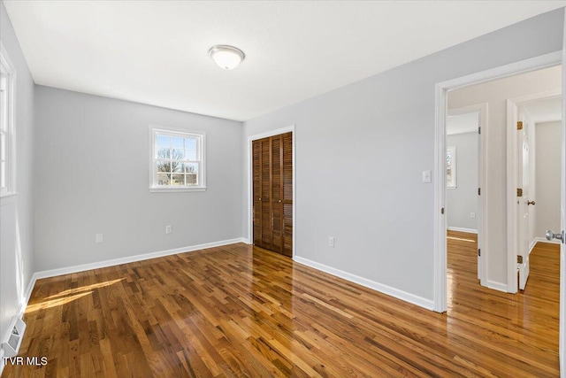 spare room featuring baseboards and wood finished floors