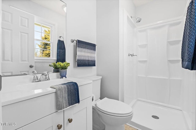 bathroom with toilet, a shower stall, and vanity