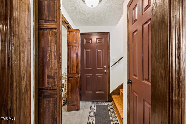 entryway featuring a textured ceiling and light tile patterned floors