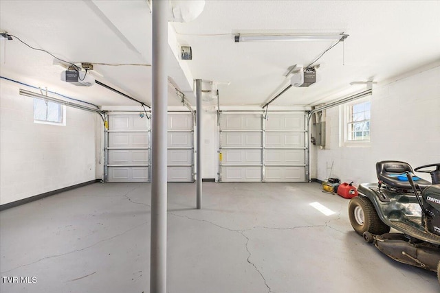 garage with a garage door opener, concrete block wall, and electric panel