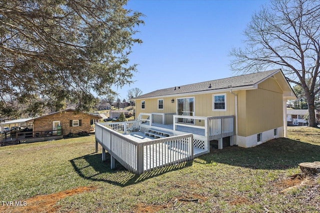 back of property featuring a lawn and a wooden deck