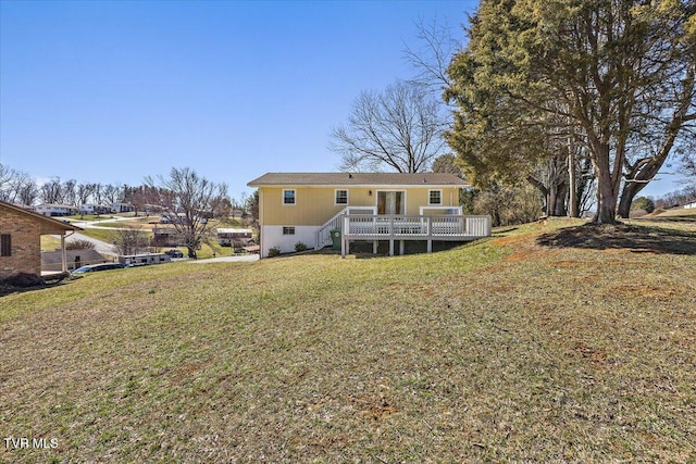 rear view of house featuring a deck and a yard