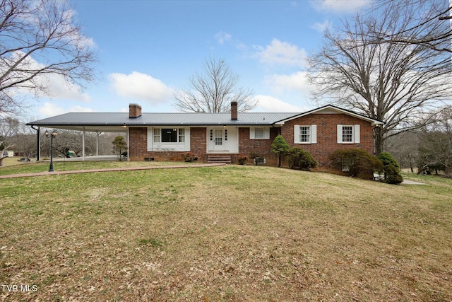 single story home with a chimney, metal roof, a front yard, and brick siding