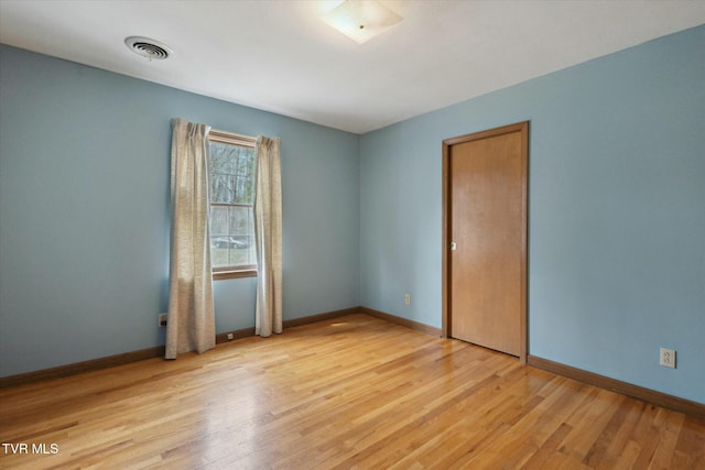 empty room with baseboards, visible vents, and light wood-style flooring
