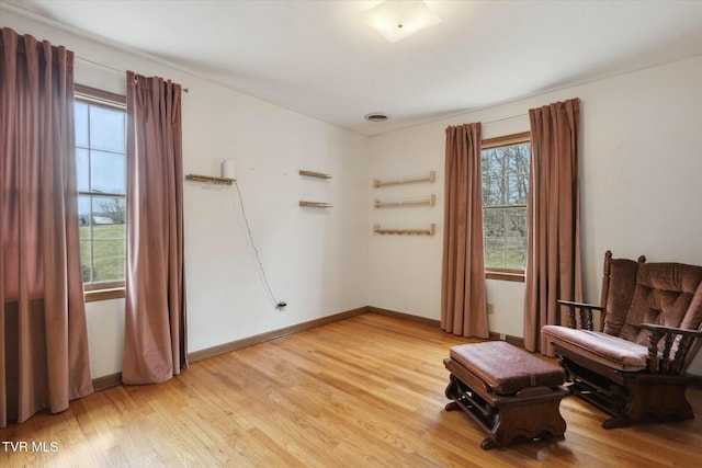 sitting room featuring visible vents, light wood-type flooring, and baseboards