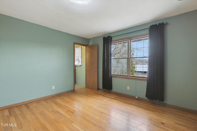 unfurnished room featuring baseboards and wood finished floors