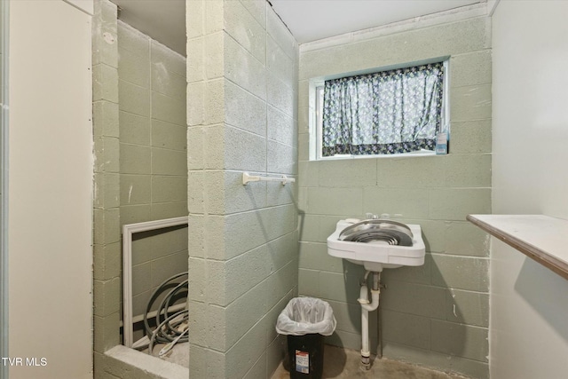 bathroom featuring concrete block wall