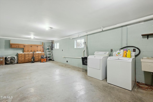 clothes washing area featuring concrete block wall, laundry area, and washing machine and dryer