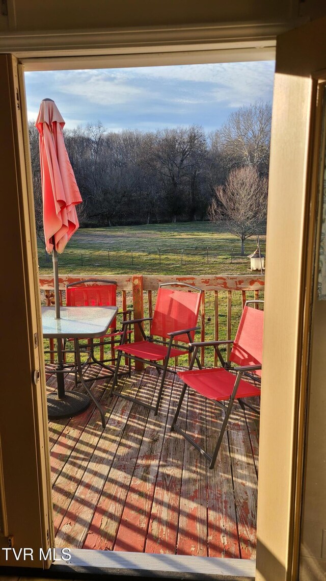 wooden deck with fence and a rural view