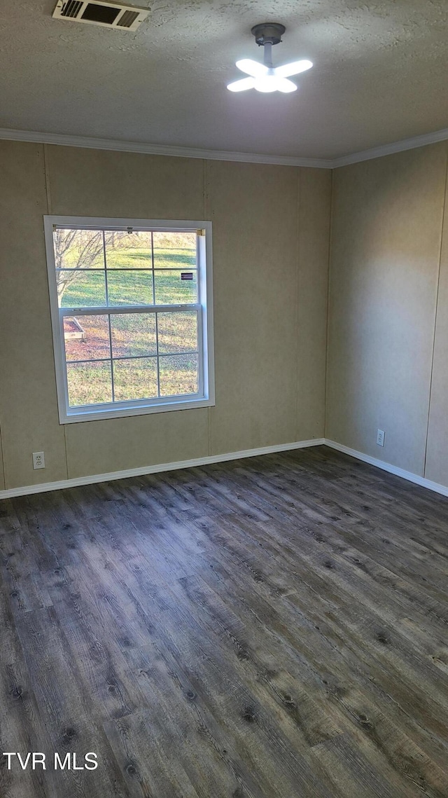 unfurnished room with ornamental molding, visible vents, a textured ceiling, and dark wood-type flooring