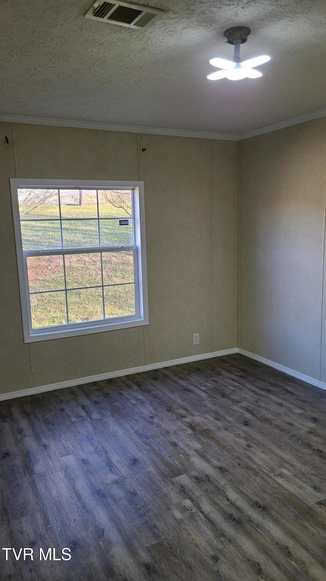 empty room featuring a textured ceiling, dark wood-style flooring, visible vents, baseboards, and crown molding