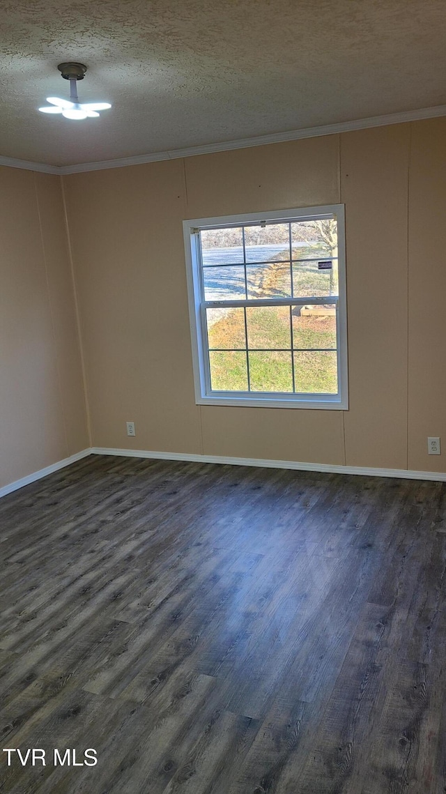 spare room featuring baseboards, a textured ceiling, ornamental molding, and dark wood-type flooring