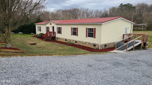 manufactured / mobile home featuring crawl space, metal roof, driveway, and a front lawn