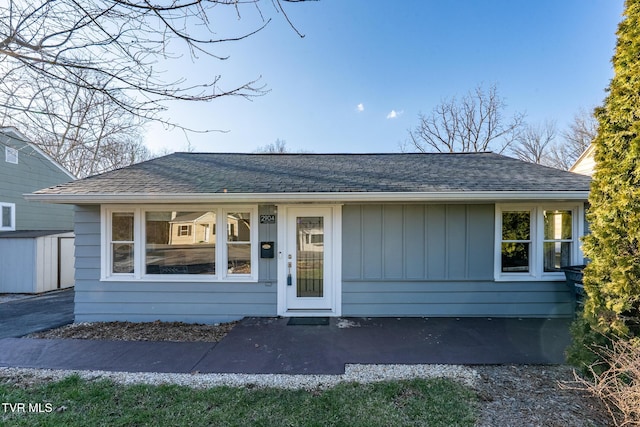 view of front of property with roof with shingles and board and batten siding