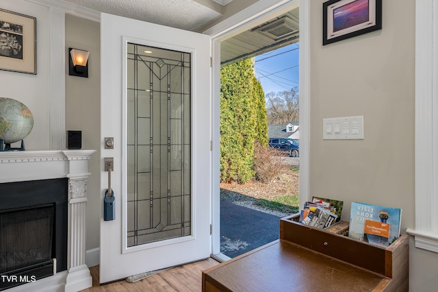 doorway with a fireplace and wood finished floors