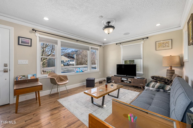 living room with a textured ceiling, baseboards, crown molding, and wood finished floors