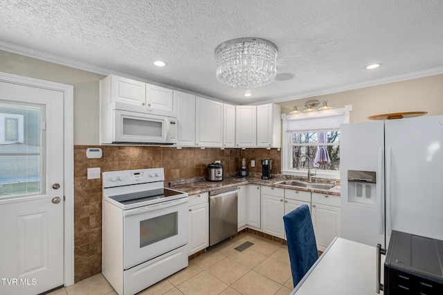 kitchen featuring white appliances, light tile patterned floors, white cabinets, a textured ceiling, and a sink