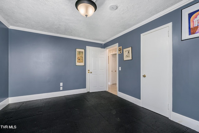 carpeted empty room featuring ornamental molding, a textured ceiling, and baseboards