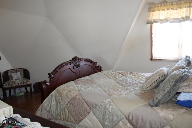 bedroom with lofted ceiling and wood finished floors