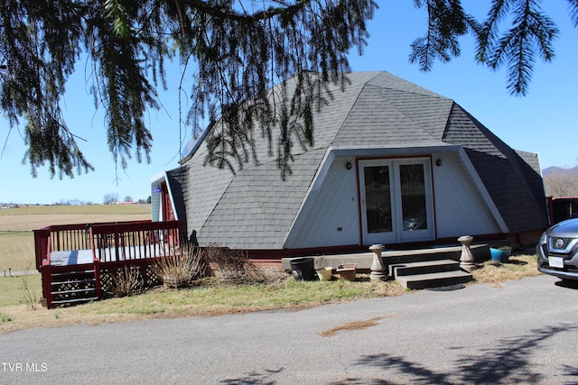 view of front of house with a shingled roof and a wooden deck