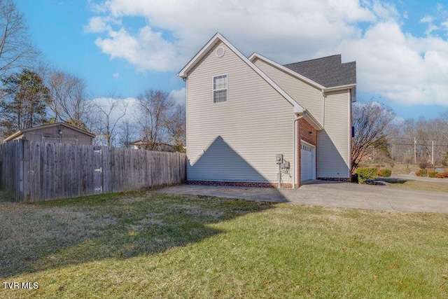 view of home's exterior with roof with shingles, fence, driveway, and a lawn