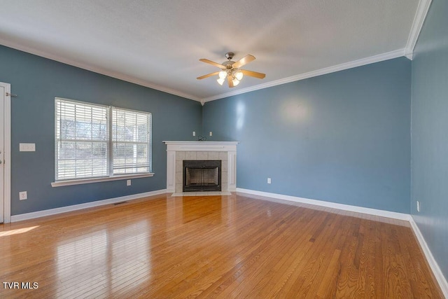 unfurnished living room featuring light wood-style floors, baseboards, a fireplace, and ornamental molding