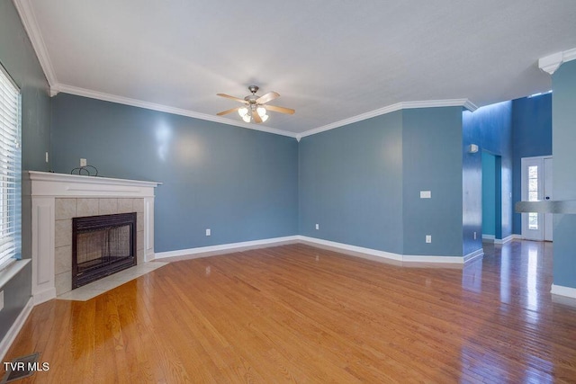 unfurnished living room featuring a fireplace, a ceiling fan, ornamental molding, wood finished floors, and baseboards