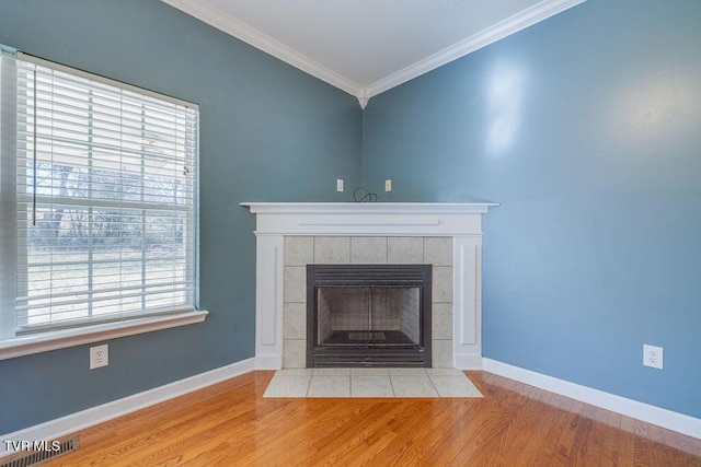 details with a tile fireplace, visible vents, wood finished floors, and ornamental molding