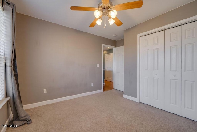 unfurnished bedroom featuring a closet, light colored carpet, ceiling fan, and baseboards