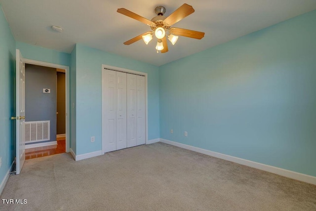 unfurnished bedroom featuring light carpet, baseboards, visible vents, a ceiling fan, and a closet