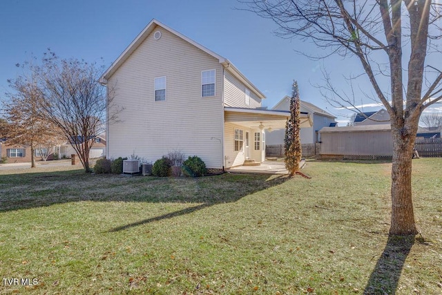 back of house with a patio area, a lawn, and central AC