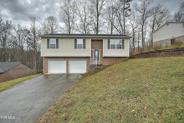 split foyer home featuring a front yard, brick siding, driveway, and an attached garage