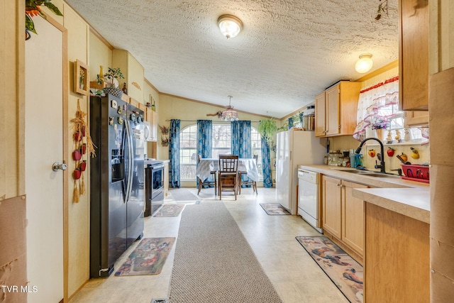 kitchen featuring lofted ceiling, light countertops, white dishwasher, fridge with ice dispenser, and a sink