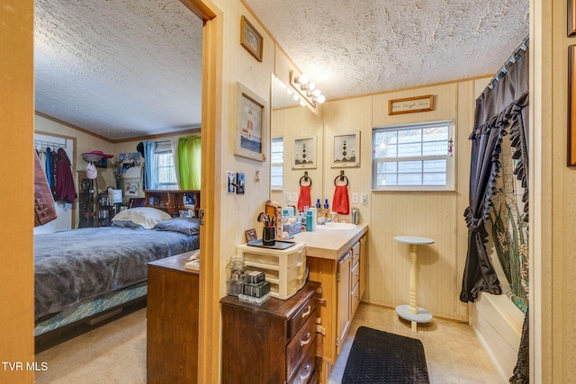 bathroom with a textured ceiling, connected bathroom, vanity, and lofted ceiling