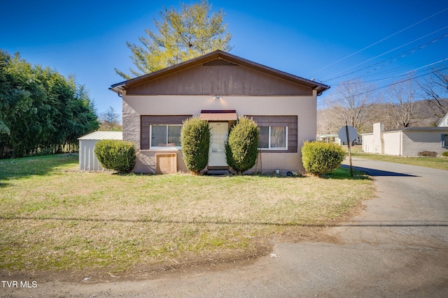 bungalow-style house featuring a front lawn