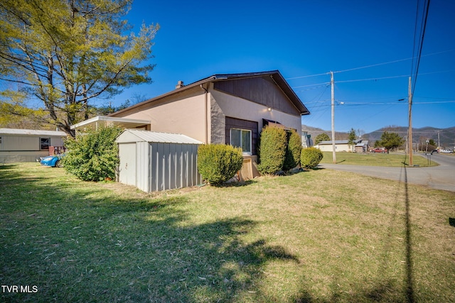 view of home's exterior with a storage unit, a lawn, and an outdoor structure