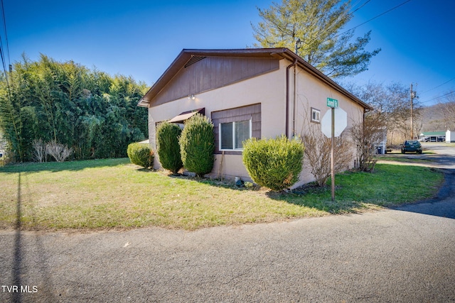 view of side of property featuring a yard and stucco siding