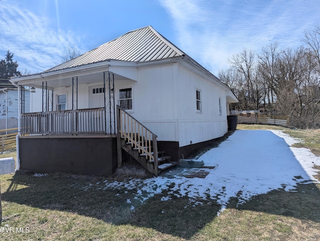 view of property exterior with covered porch and metal roof