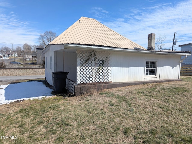 view of home's exterior with metal roof and a yard