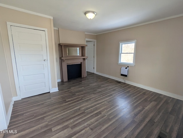 unfurnished living room with baseboards, ornamental molding, dark wood-style flooring, heating unit, and a fireplace