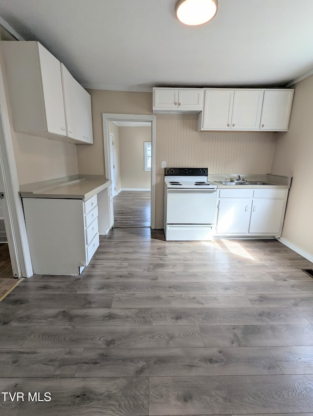 kitchen featuring light countertops, light wood-type flooring, white electric range oven, and white cabinetry