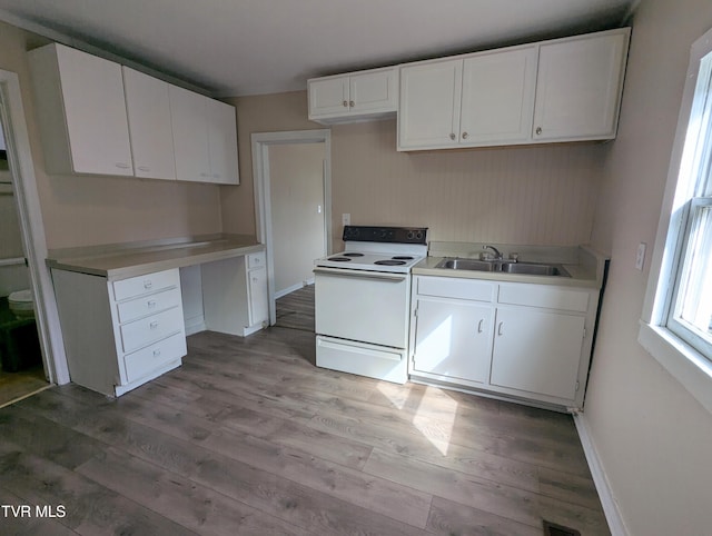 kitchen with electric range, white cabinetry, a sink, and wood finished floors