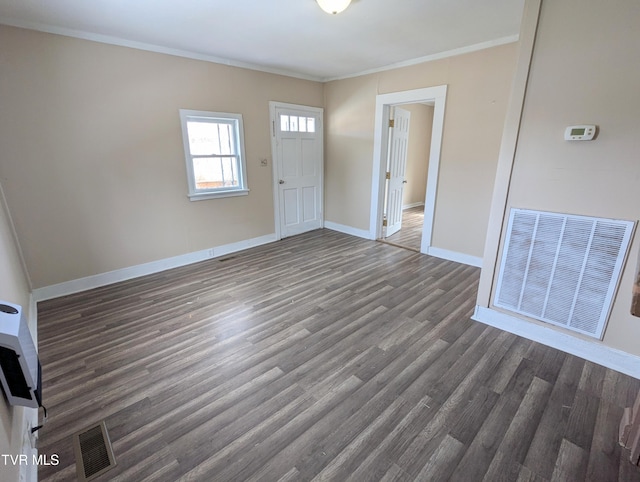 foyer entrance with baseboards, dark wood-type flooring, visible vents, and crown molding