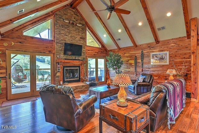 251 Fee Trl, Ewing, VA 24248 - living area with visible vents, wood walls, a stone fireplace, and hardwood / wood-style floors