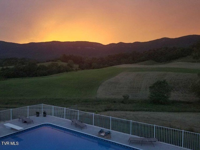 251 Fee Trl, Ewing, VA 24248 - pool at dusk featuring a patio area, fence, a mountain view, and a fenced in pool
