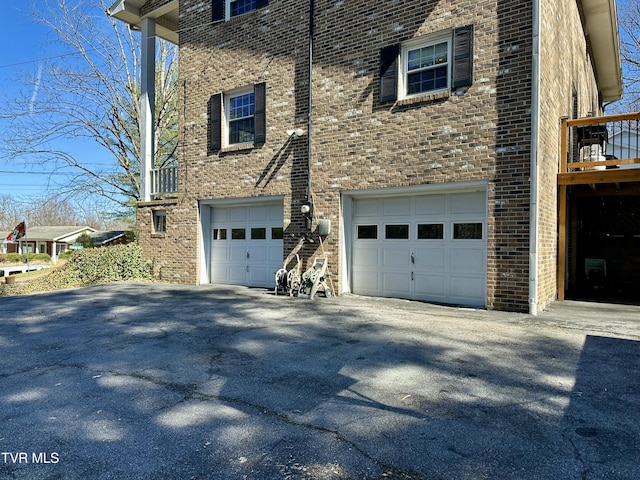 view of side of property with a garage and brick siding